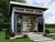 Modern studio shed with open doors, cozy interior with bookshelves, seating, and a relaxed workspace