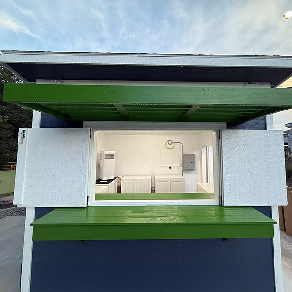 Small shed or building with green and white exterior, open door bar doors revealing white finished interior.