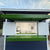 Small shed or building with green and white exterior, open door bar doors revealing white finished interior.