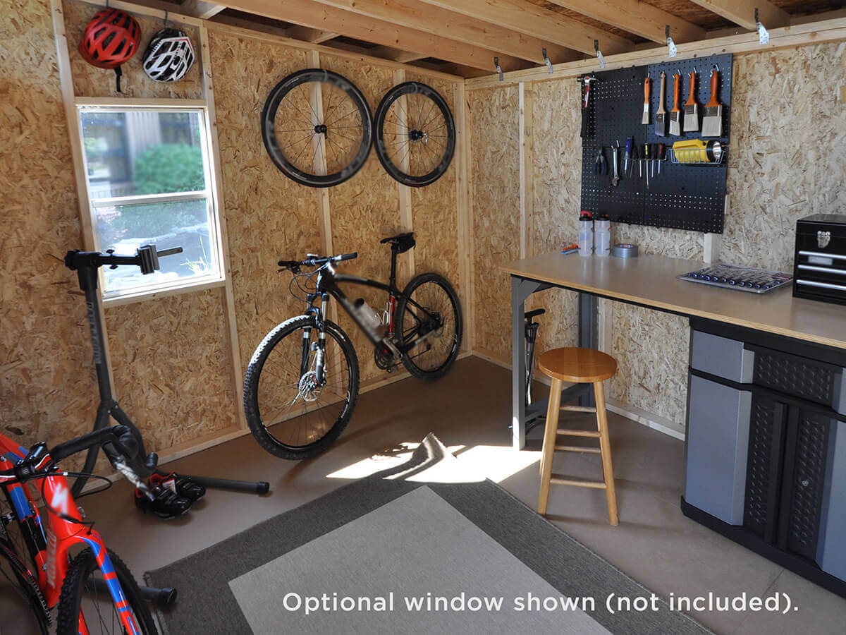 Interior of a storage shed with bikes, tools, and a workbench